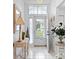 Bright foyer with white tile flooring, decorative mirror, and glass front door at 4610 Runabout Way, Bradenton, FL 34203