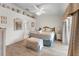 Bright bedroom featuring a large bed, light wood floors, light walls, and a door leading outside at 4610 Runabout Way, Bradenton, FL 34203