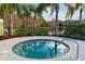 Community hot tub with a lake view, metal safety railing, and tropical landscaping at 4814 Lake Breeze Ter, Sarasota, FL 34243