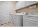 A well-equipped laundry room with a washer, dryer, cabinets, and a sink for added convenience at 4814 Lake Breeze Ter, Sarasota, FL 34243