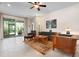 Cozy living room with tile floors, ceiling fan, and sliding glass doors to a screened lanai at 4814 Lake Breeze Ter, Sarasota, FL 34243