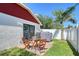 Backyard with a small brick patio, outdoor dining set, grills, and a lush lawn at 4838 San Ortebello Dr, Bradenton, FL 34208