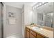 Bathroom with a single sink vanity, framed mirror with vanity lighting, and glass-enclosed shower at 4838 San Ortebello Dr, Bradenton, FL 34208