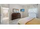 Sunlit bedroom with wood-look floors, dresser with mirror, and a TV mounted on the wall at 4838 San Ortebello Dr, Bradenton, FL 34208
