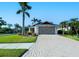 Inviting home exterior showcasing a paved driveway and lush landscaping with palm trees at 4838 San Ortebello Dr, Bradenton, FL 34208