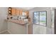 Kitchen with oak cabinets, white appliances, tile floor, and sliding doors to the backyard at 4838 San Ortebello Dr, Bradenton, FL 34208
