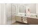 Bright bathroom featuring a double sink vanity with towel storage and a spacious glass-enclosed shower at 4950 Remington Dr # 114, Sarasota, FL 34234