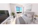 Sunlit bedroom with neutral color scheme, large windows with views, and minimalist decor at 4950 Remington Dr # 114, Sarasota, FL 34234