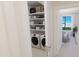 Convenient in-unit laundry closet with stacked washer and dryer, and storage shelves at 4950 Remington Dr # 114, Sarasota, FL 34234