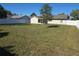 Large backyard with a white fence, tree, and screened porch at 5002 26Th Avenue Dr E, Palmetto, FL 34221