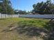 Large, fenced-in backyard with a mix of lush green grass and mature trees at 5002 26Th Avenue Dr E, Palmetto, FL 34221