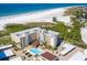 Condo community featuring a pool, beach access, and covered parking at 5780 Midnight Pass Rd # 410, Sarasota, FL 34242