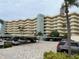 Multi-story condo building exterior featuring parking under building and several outdoor balconies at 5780 Midnight Pass Rd # 410, Sarasota, FL 34242