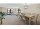 Living room and dining area with neutral walls and carpet with a view of the outside at 5780 Midnight Pass Rd # 410, Sarasota, FL 34242