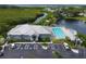 Aerial view of the clubhouse, pool, and parking area bordered by mangroves and serene waterfront views at 623 Estuary Dr, Bradenton, FL 34209