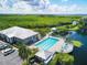 Aerial view of pool and clubhouse area near a waterway, showcasing the community's beautiful waterfront amenities at 623 Estuary Dr, Bradenton, FL 34209