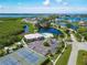 Aerial view showcases tennis courts, clubhouse, pool, parking and surrounding serene landscaping and waterways at 623 Estuary Dr, Bradenton, FL 34209