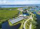 Aerial view showcasing the community's pools, tennis courts, surrounding lakes and lush landscaping at 623 Estuary Dr, Bradenton, FL 34209