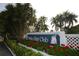 Community sign with 'Perico Bay Club' displayed, enhanced by red flowers and lush tropical landscaping at 623 Estuary Dr, Bradenton, FL 34209