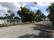 Community entrance featuring the 'Perico Bay Club' sign, mature palms, and manicured landscaping at 623 Estuary Dr, Bradenton, FL 34209