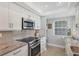 Bright kitchen features stainless steel appliances, granite countertops, and white cabinets at 623 Estuary Dr, Bradenton, FL 34209