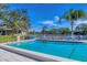 Community pool offers a serene setting with comfortable lounge chairs, blue umbrellas and lake views at 623 Estuary Dr, Bradenton, FL 34209