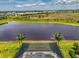 Aerial view of a pool and lake showcasing the backyard's design, landscaping, and waterfront setting at 6252 Winding Pine Dr, Nokomis, FL 34275