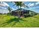 Landscaped backyard with screened lanai and lush green lawn perfect for outdoor activities and relaxation at 6252 Winding Pine Dr, Nokomis, FL 34275