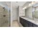 Modern bathroom featuring a double vanity, granite countertops, and a glass-enclosed shower at 6252 Winding Pine Dr, Nokomis, FL 34275