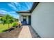 Inviting front entry features a brick pathway, cozy seating, and lush landscaping, creating a warm welcome at 6252 Winding Pine Dr, Nokomis, FL 34275