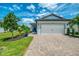 Charming home features a spacious two-car garage and meticulously landscaped front yard with a brick driveway at 6252 Winding Pine Dr, Nokomis, FL 34275
