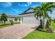 Charming home features a spacious two-car garage and meticulously landscaped front yard with a brick driveway at 6252 Winding Pine Dr, Nokomis, FL 34275