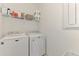 Clean laundry room with a modern washer and dryer, and convenient shelving for supplies at 6252 Winding Pine Dr, Nokomis, FL 34275