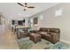 Spacious living room featuring tile floors, comfortable leather furniture, and a stylish ceiling fan at 6252 Winding Pine Dr, Nokomis, FL 34275