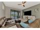 Comfortable living room with leather seating, fan, and access to the outdoor pool area at 6252 Winding Pine Dr, Nokomis, FL 34275