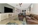 Open-concept living area features tile floors, leather seating, and a sleek TV console at 6252 Winding Pine Dr, Nokomis, FL 34275