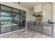 Outdoor kitchen featuring built-in grill, stainless steel appliances, and views of the pool at 6252 Winding Pine Dr, Nokomis, FL 34275
