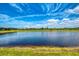 Backyard view of a tranquil pond in a well-maintained backyard. The pond offers a peaceful ambiance at 6252 Winding Pine Dr, Nokomis, FL 34275