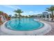 Beautiful community pool featuring waterfall, mature palm trees, and plenty of lounge chairs at 6252 Winding Pine Dr, Nokomis, FL 34275