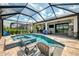 Gorgeous screened-in pool with hot tub, patio seating, and luxurious backyard at 6252 Winding Pine Dr, Nokomis, FL 34275