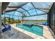 Tranquil screened-in pool with a hot tub overlooking a serene lake view and lush landscaping at 6252 Winding Pine Dr, Nokomis, FL 34275