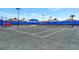 Tennis court is surrounded by black fencing and a covered bench for a place to rest during a match at 6252 Winding Pine Dr, Nokomis, FL 34275