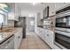 Modern kitchen boasts white cabinets, granite countertops, and stainless steel appliances at 6422 Beechwood Ave, Sarasota, FL 34231