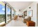 Inviting sunroom with a dining set, cozy wicker chairs, and panoramic views of the ocean and foliage at 6460 Mourning Dove Dr # 102, Bradenton, FL 34210