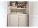 Laundry area with a stacked washer and dryer, as well as upper shelves for supplies at 6460 Mourning Dove Dr # 102, Bradenton, FL 34210