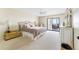 Bright and airy main bedroom with a large bed, cozy furnishings, and balcony access with ocean views at 6460 Mourning Dove Dr # 102, Bradenton, FL 34210