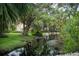 A tranquil pond surrounded by tropical foliage and towering trees, creating a serene natural landscape at 6460 Mourning Dove Dr # 102, Bradenton, FL 34210