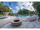 A serene pool and hot tub area with comfortable lounge chairs and a cozy brick fire pit at 6460 Mourning Dove Dr # 102, Bradenton, FL 34210