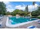 Large rectangular community pool with chairs and lush landscaping under a beautiful blue sky at 6460 Mourning Dove Dr # 102, Bradenton, FL 34210