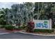 Community sign reading 'Wild Oak Bay' surrounded by lush landscaping and palm trees at 6460 Mourning Dove Dr # 102, Bradenton, FL 34210